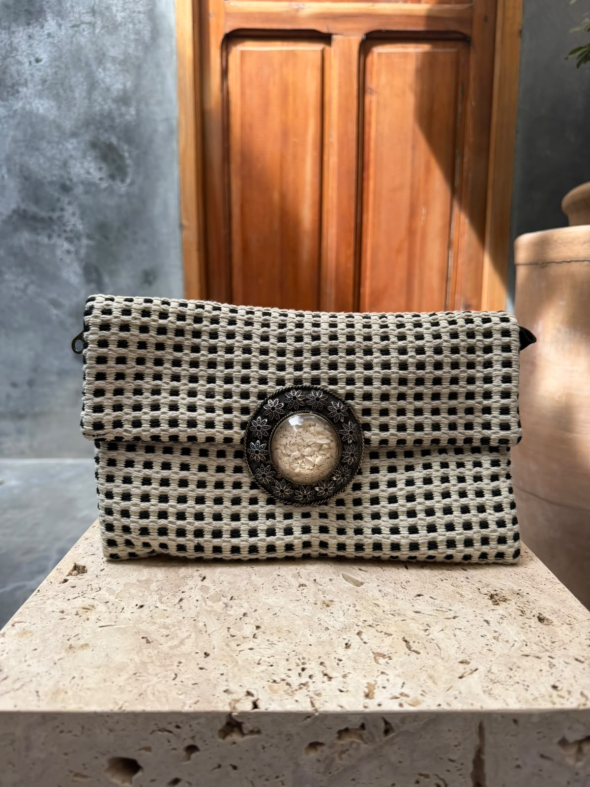 Cream-and-black checked carpet bag with a pale circular centrepiece and dark floral surround
