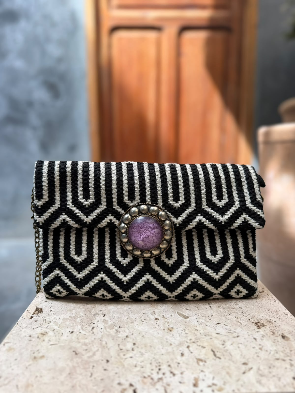 Black-and-white geometric carpet bag with a purple circular centrepiece and metallic surround