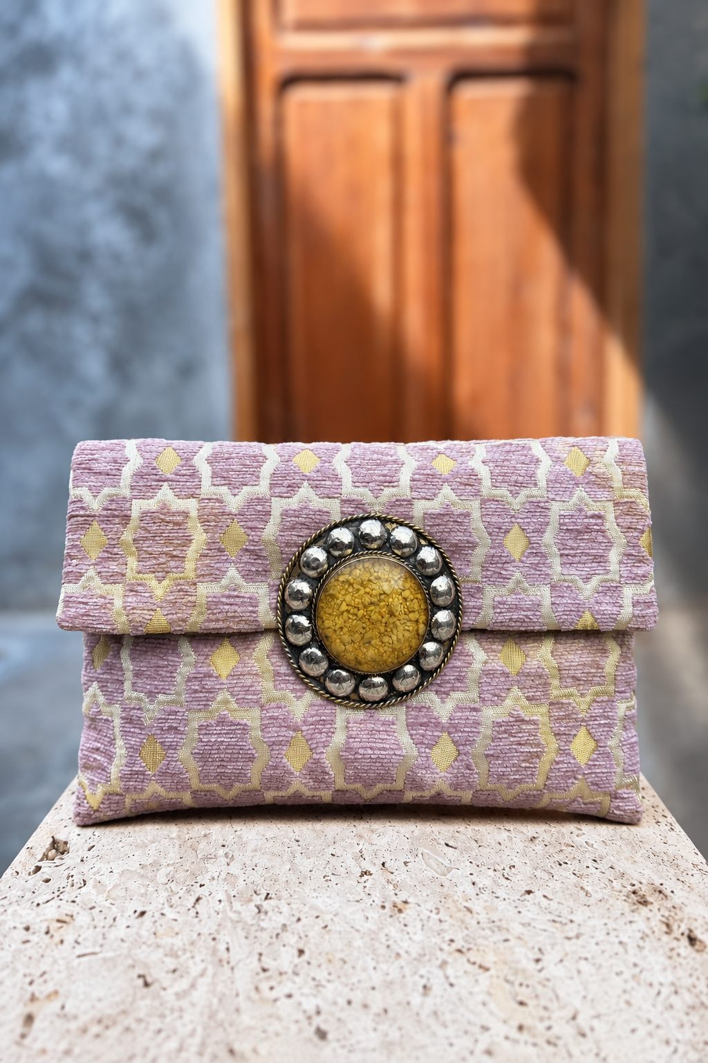 Rose Magic lilac-and-cream carpet bag with yellow centrepiece on a beige stone pedestal