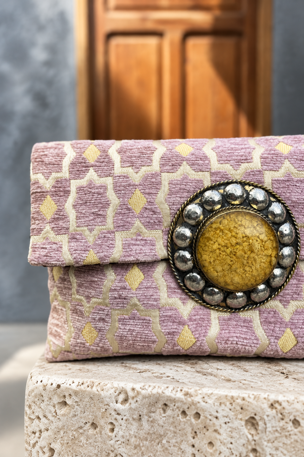 Close-up of Rose Magic's yellow decorative centrepiece and lilac textured fabric with matching wooden doorway background